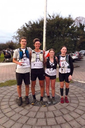 Corin, Toby, Payton and Jenna stand smiling for a photo with their sports gear on, including backpacks.