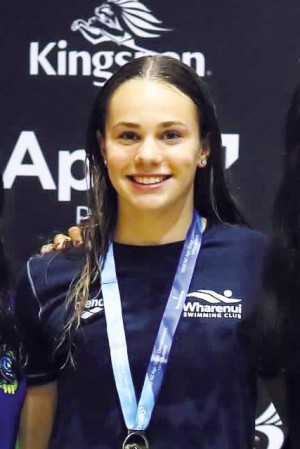 Rylee smiles for photo with a medal she has won around her neck.