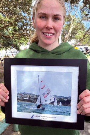 Gabriella Kenton-Smith (Y13) holding image of her sailing in competition.